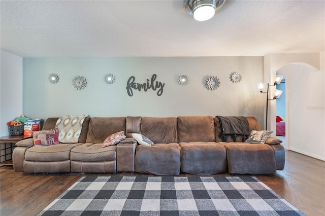 living room with dark hardwood / wood-style flooring and a textured ceiling