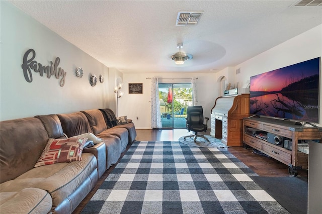 living room with dark hardwood / wood-style flooring and a textured ceiling