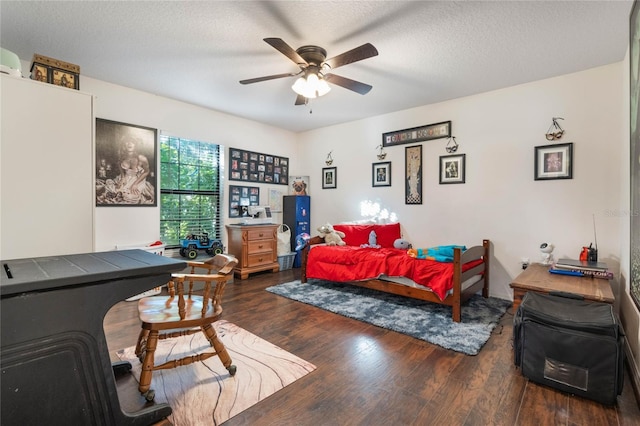 bedroom featuring ceiling fan, a textured ceiling, and dark hardwood / wood-style flooring