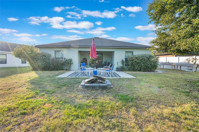 back of house with a patio area, a fire pit, and a lawn