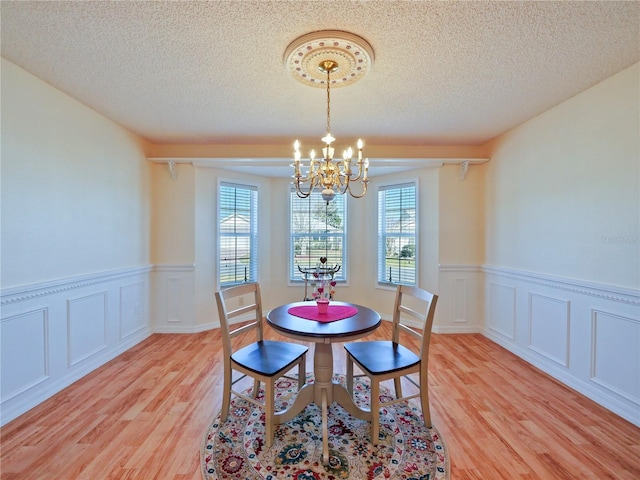 dining room featuring an inviting chandelier, plenty of natural light, and light wood-type flooring