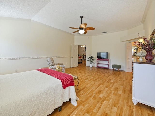 bedroom featuring lofted ceiling, ceiling fan, ornamental molding, light hardwood / wood-style floors, and a textured ceiling