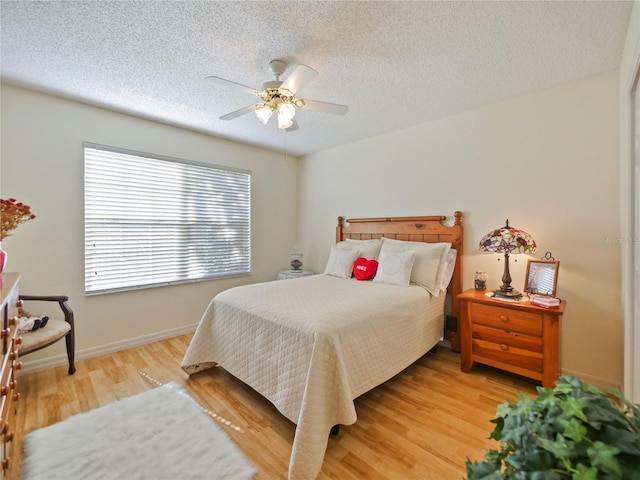bedroom with hardwood / wood-style floors, a textured ceiling, and ceiling fan