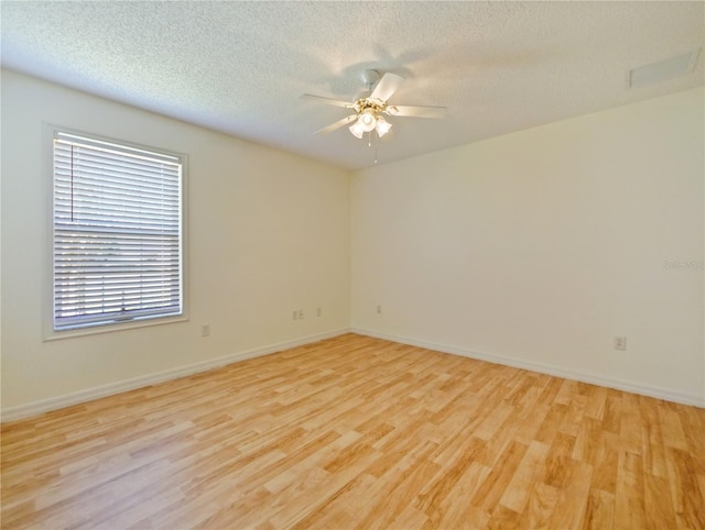 spare room featuring a textured ceiling, light hardwood / wood-style flooring, and ceiling fan