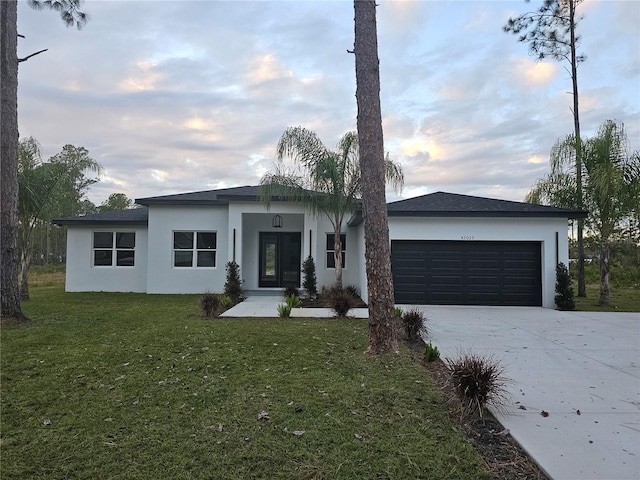 view of front of home with a garage and a front lawn