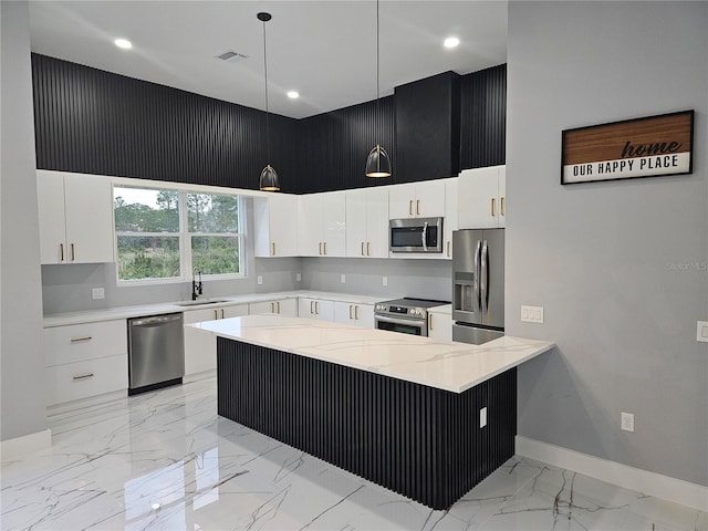 kitchen with white cabinetry, stainless steel appliances, a high ceiling, and hanging light fixtures