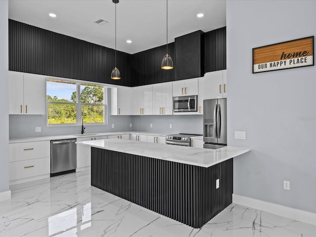 kitchen with stainless steel appliances, white cabinetry, a high ceiling, and pendant lighting