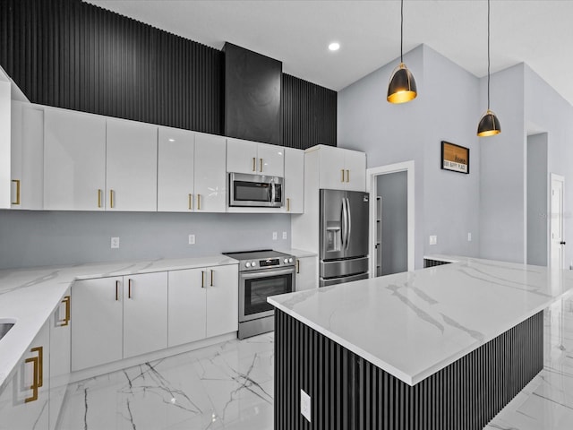 kitchen with decorative light fixtures, light stone counters, white cabinets, and stainless steel appliances