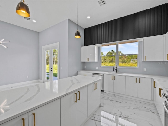 kitchen with french doors, decorative light fixtures, sink, white cabinetry, and light stone counters