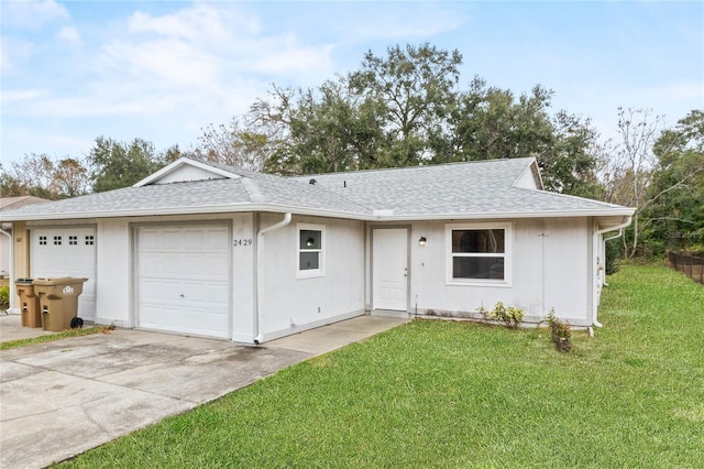 single story home with a garage and a front lawn