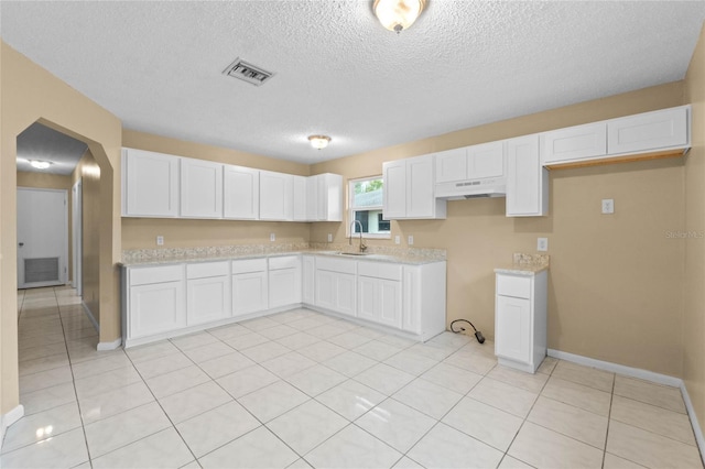 kitchen with sink, white cabinetry, and light tile patterned floors