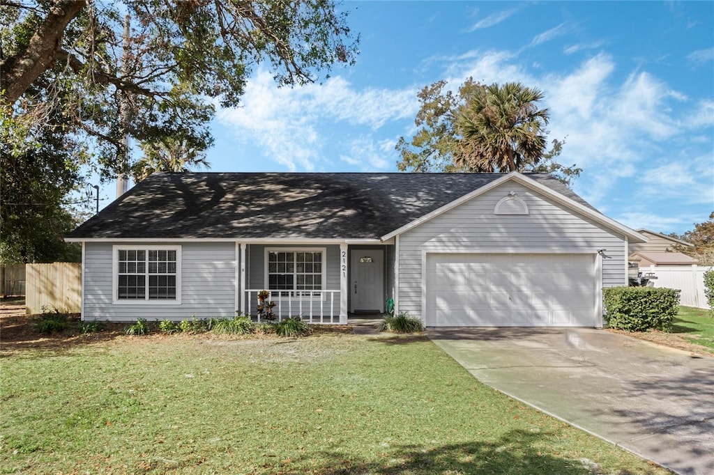 ranch-style home with a garage, a front lawn, and a porch