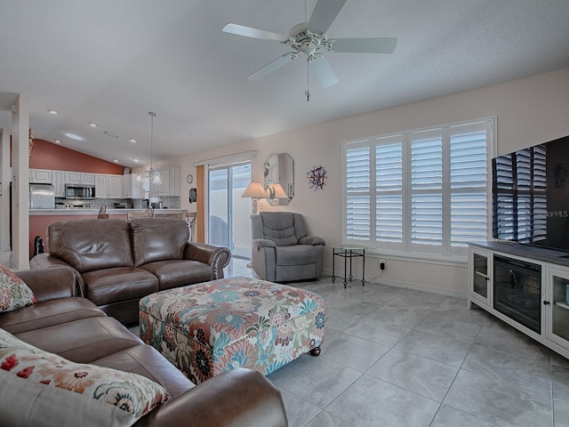 living room with lofted ceiling, ceiling fan, plenty of natural light, and light tile patterned flooring