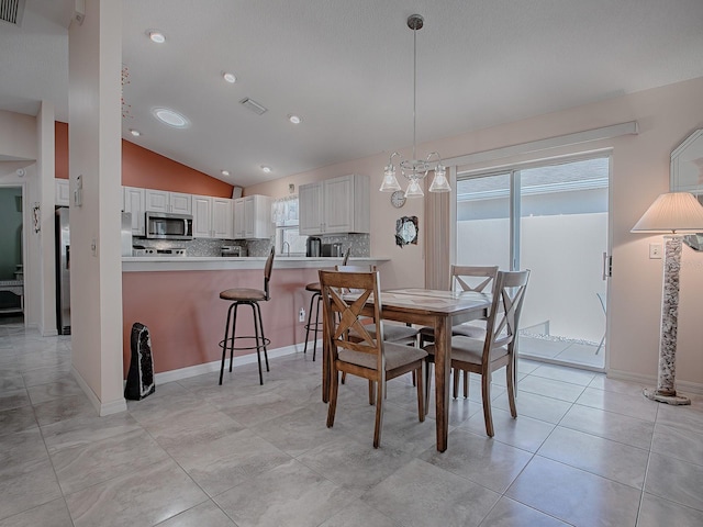 dining area featuring vaulted ceiling and light tile patterned flooring