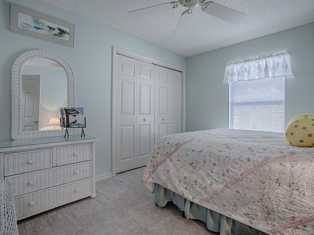 bedroom featuring ceiling fan, a textured ceiling, and a closet