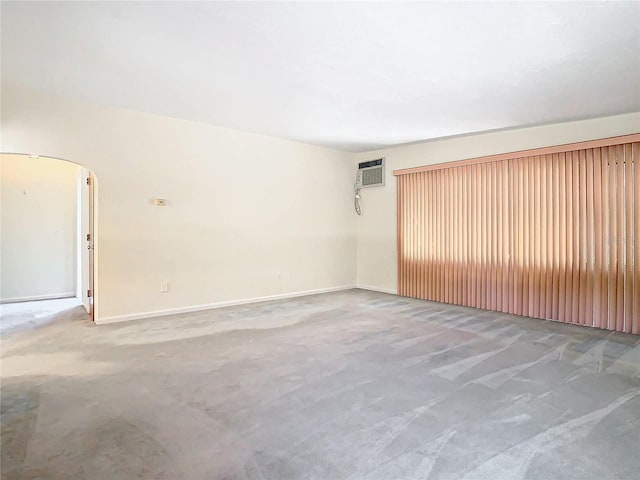 unfurnished room featuring an AC wall unit and concrete floors