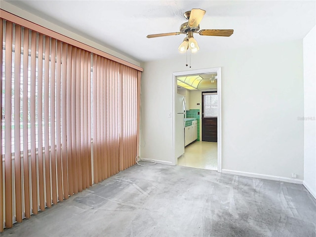 carpeted spare room with ceiling fan