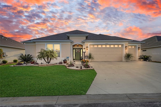 5857 Mackenzie Ave, The Villages, FL 32163 - view of front of property featuring a yard, stucco siding, an attached garage, and concrete driveway