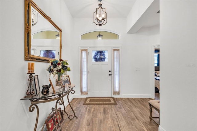 5857 Mackenzie Ave, The Villages, FL 32163 - foyer with baseboards, wood finished floors, and a chandelier