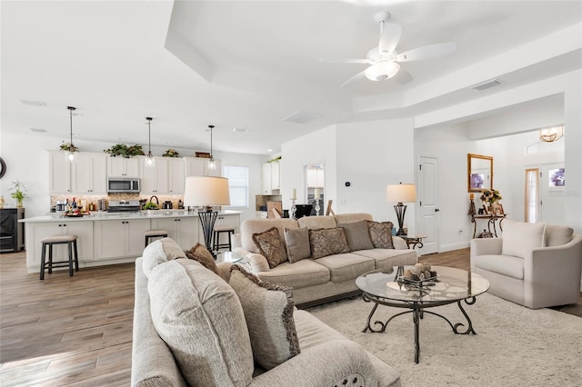 5857 Mackenzie Ave, The Villages, FL 32163 - living room featuring a raised ceiling, light wood finished floors, and visible vents