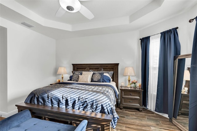 5857 Mackenzie Ave, The Villages, FL 32163 - bedroom featuring a tray ceiling, baseboards, wood tiled floor, visible vents, and ceiling fan
