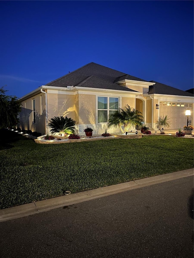 5857 Mackenzie Ave, The Villages, FL 32163 - view of front facade featuring stucco siding, an attached garage, and a yard