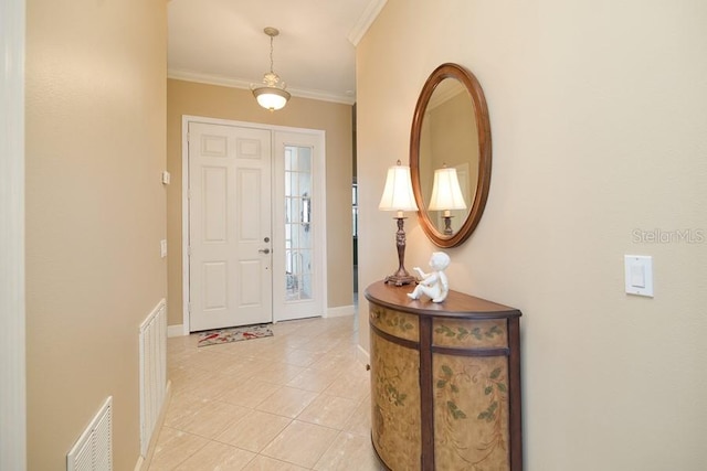 foyer with light tile patterned flooring, baseboards, visible vents, and ornamental molding