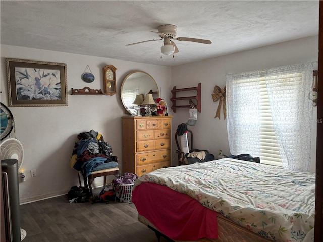 bedroom with ceiling fan, a textured ceiling, and dark hardwood / wood-style flooring