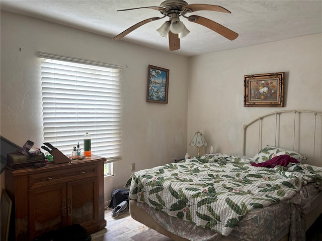 bedroom featuring ceiling fan, light wood-type flooring, and a textured ceiling