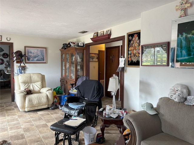 living room with a textured ceiling and light tile patterned floors