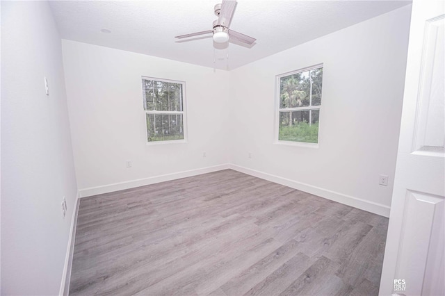 unfurnished room featuring ceiling fan, light hardwood / wood-style floors, a textured ceiling, and a wealth of natural light