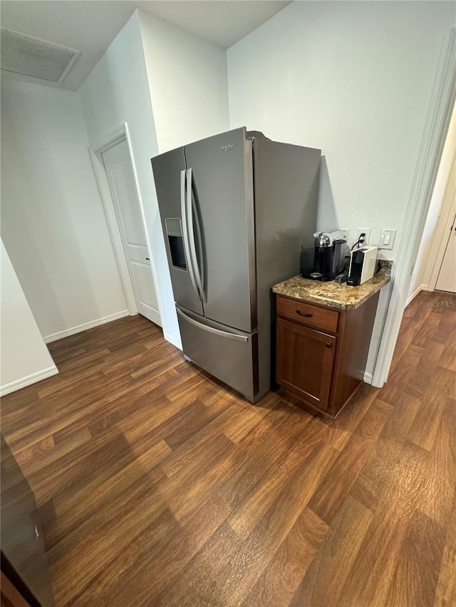 kitchen with light stone counters, stainless steel fridge with ice dispenser, and dark hardwood / wood-style floors