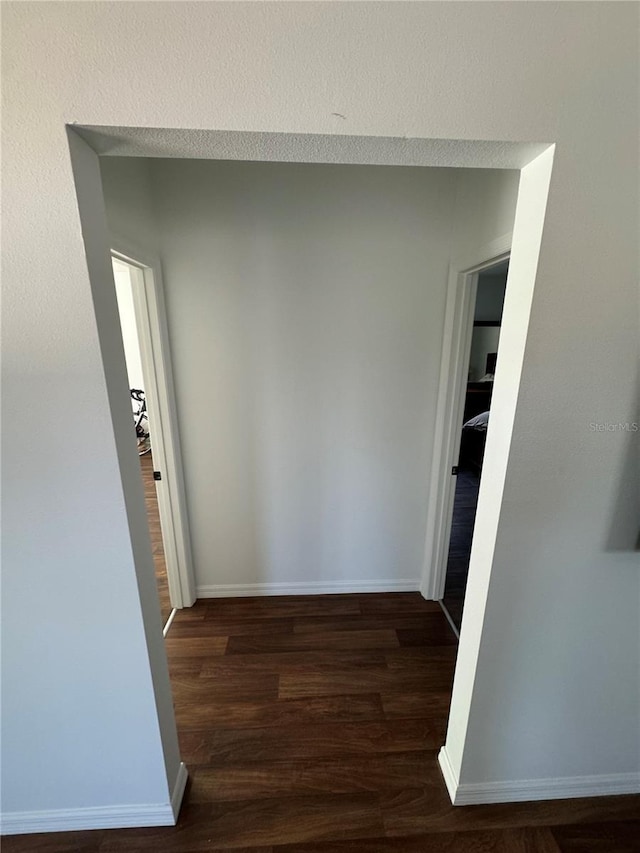 corridor featuring dark hardwood / wood-style flooring and a textured ceiling