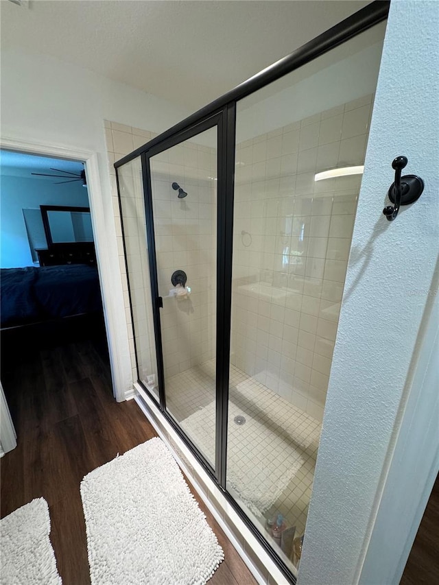 bathroom with wood-type flooring and a shower with shower door