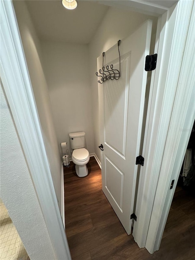 bathroom featuring wood-type flooring and toilet