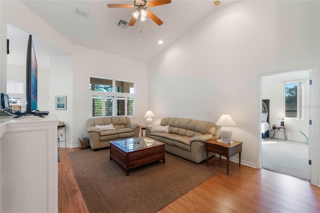 living room with high vaulted ceiling, ceiling fan, and hardwood / wood-style floors