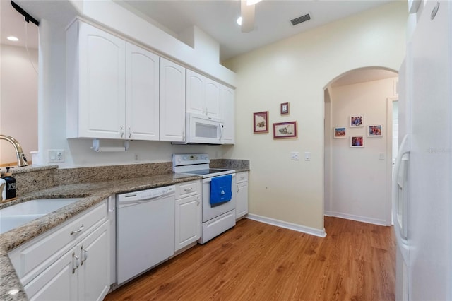 kitchen featuring white cabinetry, sink, stone countertops, and white appliances