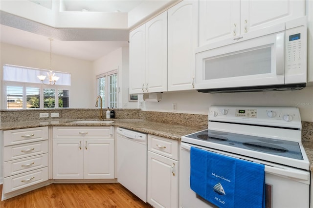 kitchen with sink, white appliances, and white cabinetry