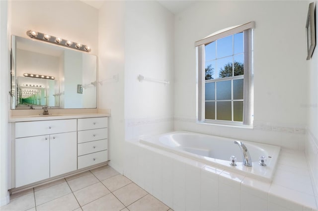 bathroom with tiled tub, vanity, and tile patterned flooring