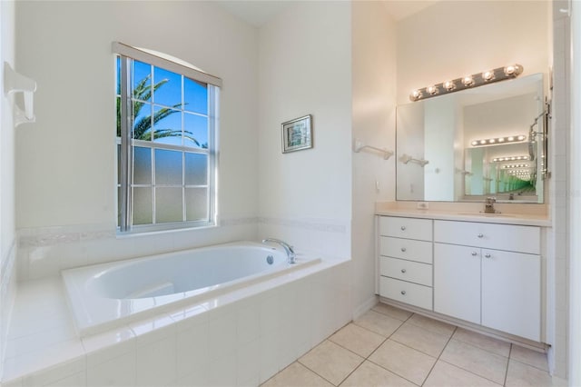 bathroom featuring tiled tub, vanity, and tile patterned flooring