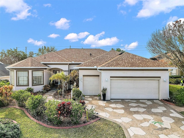 single story home featuring driveway, a shingled roof, and stucco siding