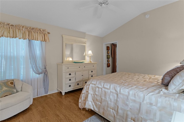 bedroom with ceiling fan, lofted ceiling, and wood-type flooring