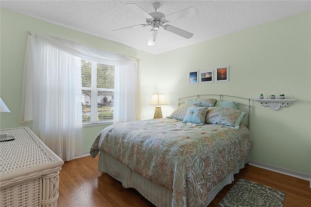 bedroom with ceiling fan, a textured ceiling, and hardwood / wood-style flooring