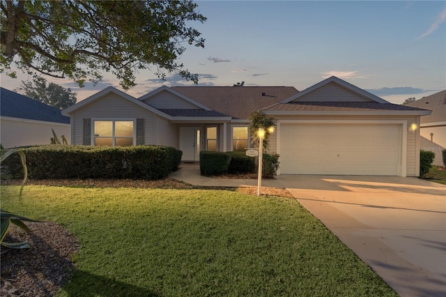 ranch-style house featuring a yard and a garage