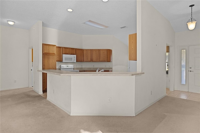 kitchen with vaulted ceiling, hanging light fixtures, white appliances, light carpet, and a textured ceiling