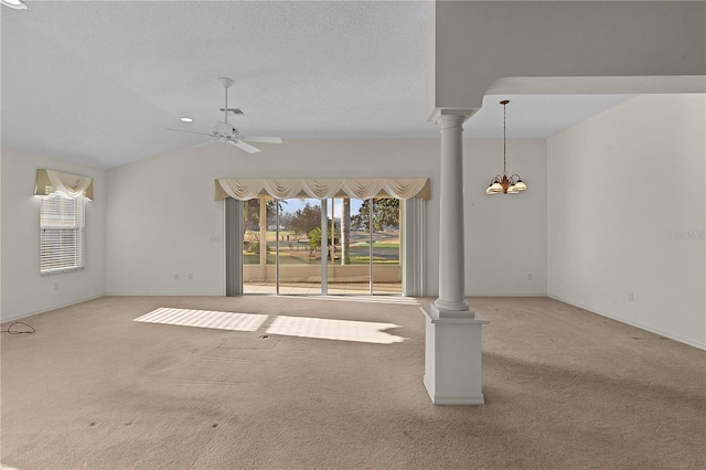 unfurnished living room with decorative columns, vaulted ceiling, and light colored carpet