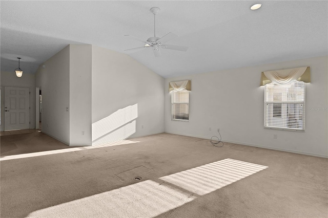 unfurnished living room with ceiling fan, lofted ceiling, carpet, and a textured ceiling