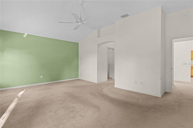 carpeted empty room featuring ceiling fan and high vaulted ceiling