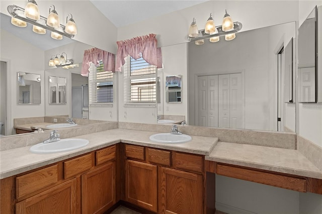 bathroom with vanity, vaulted ceiling, and a shower with shower door