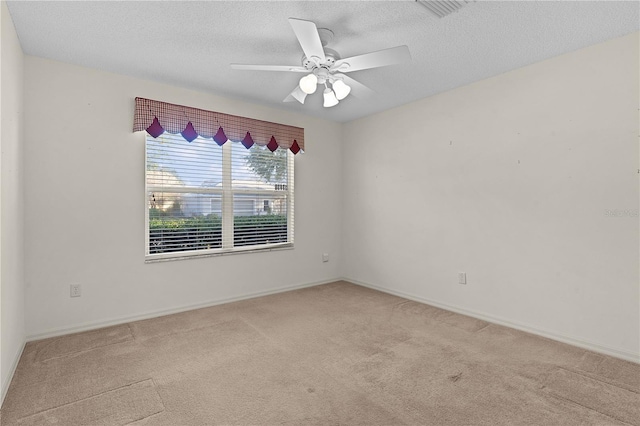 carpeted empty room with ceiling fan and a textured ceiling